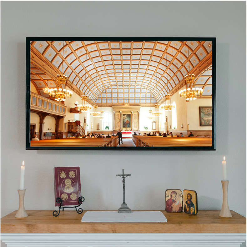 Vaaleallan alttarin yläpuolella televisio, jossa kuva Kangasalan kirkon sisältä.