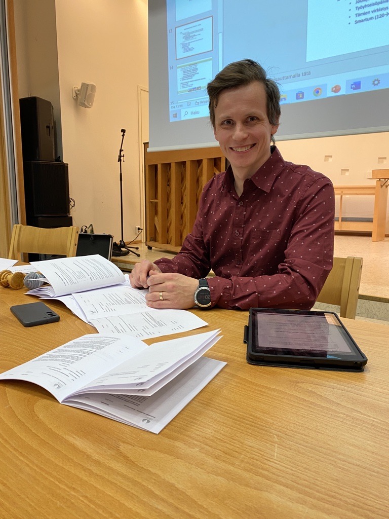 Kirkkovaltuuston uusi puheenjohtaja Ville Keskinen istuu kokouspöydän ääressä